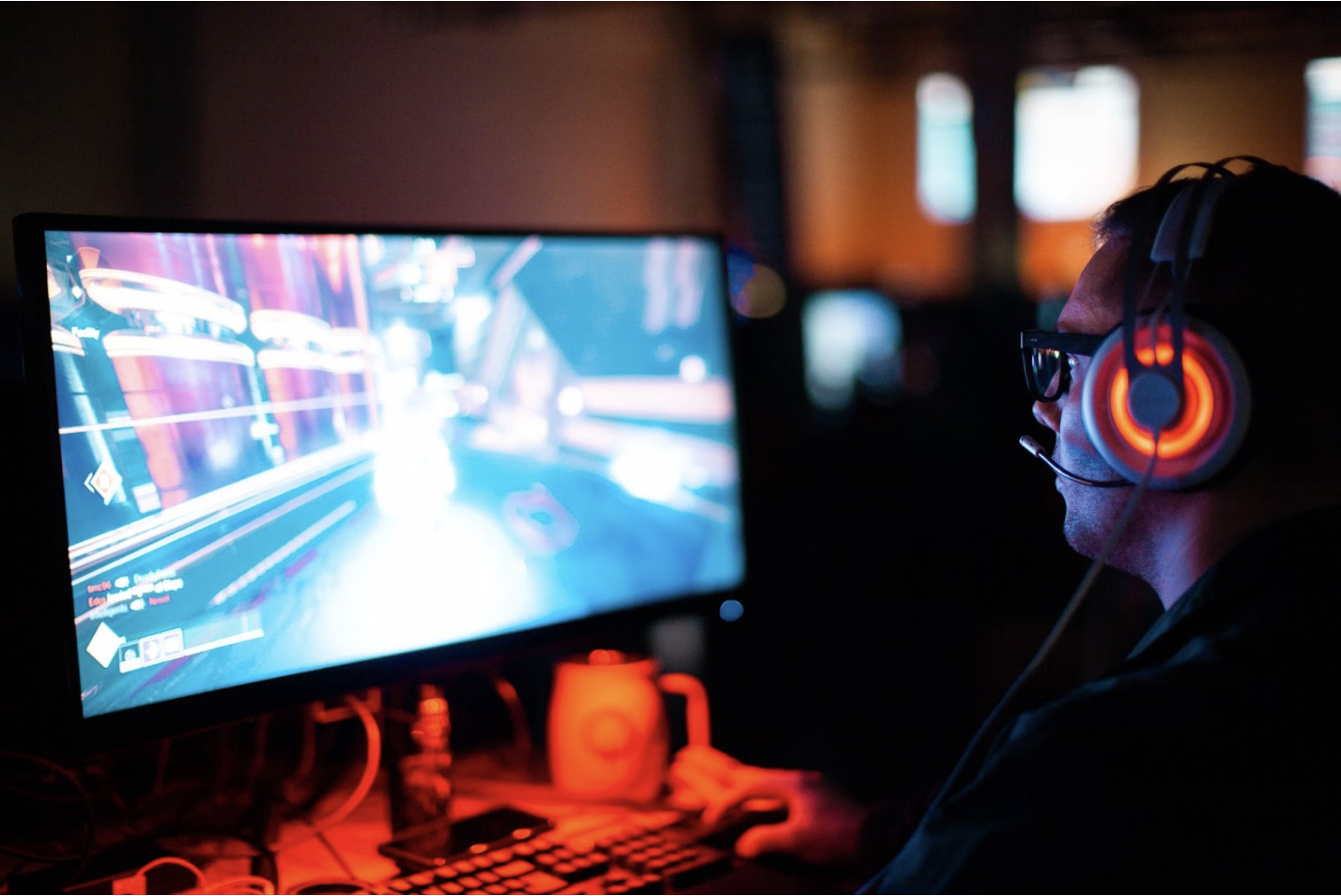 a person playing a video game on a desktop in a dark room