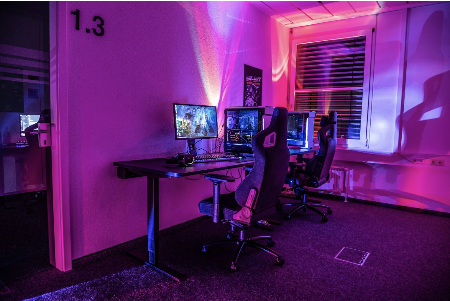 Neon pink-and-purple gaming room with two computer stations