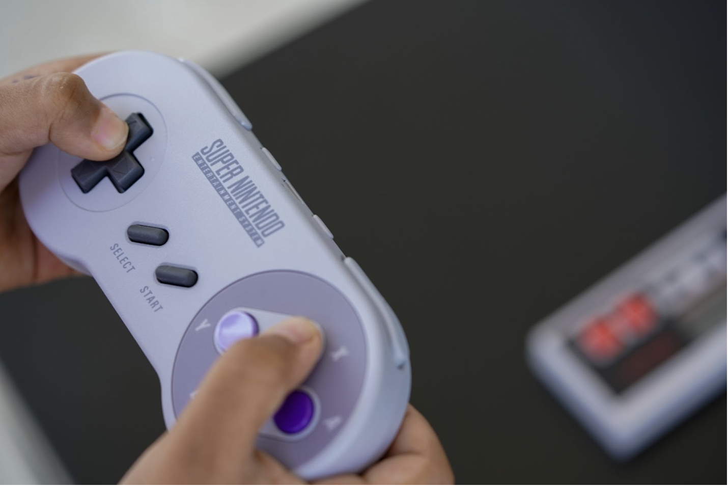 a hand holding Super Mario video game controller