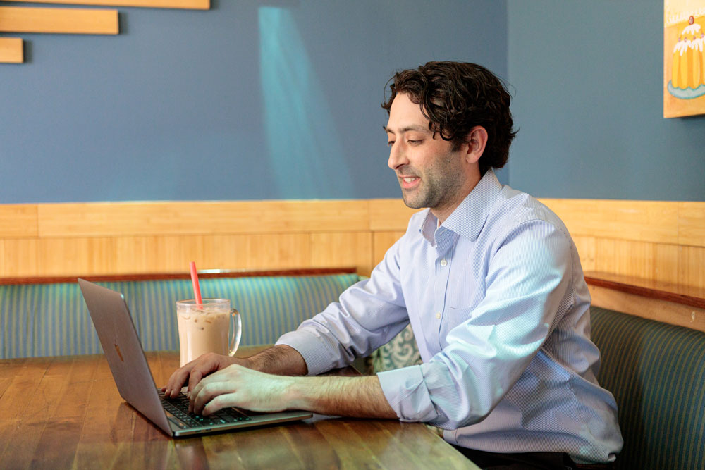 adult online learner working at coffee shop