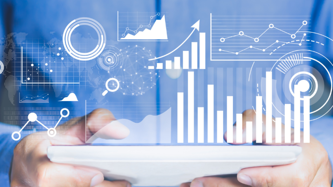 Hands holding a tablet projecting data and charts above it