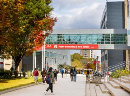 NJIT campus bridge with students walking under