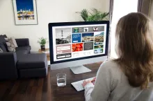 Female student sitting at home in front of a computer monitor working on designing her eportfolio